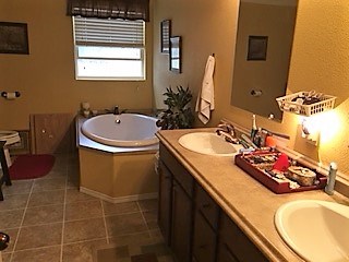 master bath with double vanity and garden tub